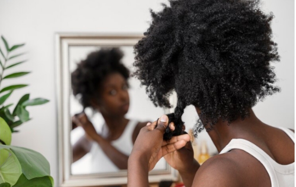 Natural 4C hair being styled into twists as a protective hairstyle