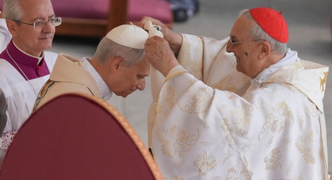Pope receiving the pallium, a white woolen band worn over his shoulders.