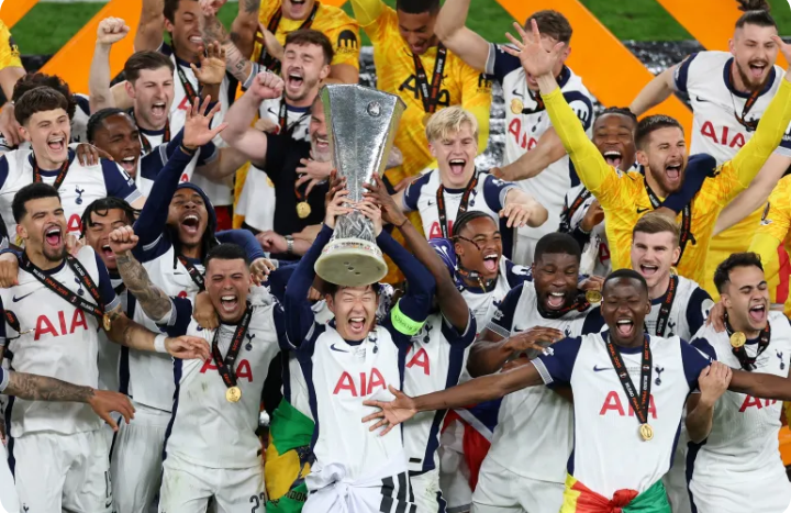 Son Heung-min lifting the Europa League trophy as Tottenham teammates celebrate around him.