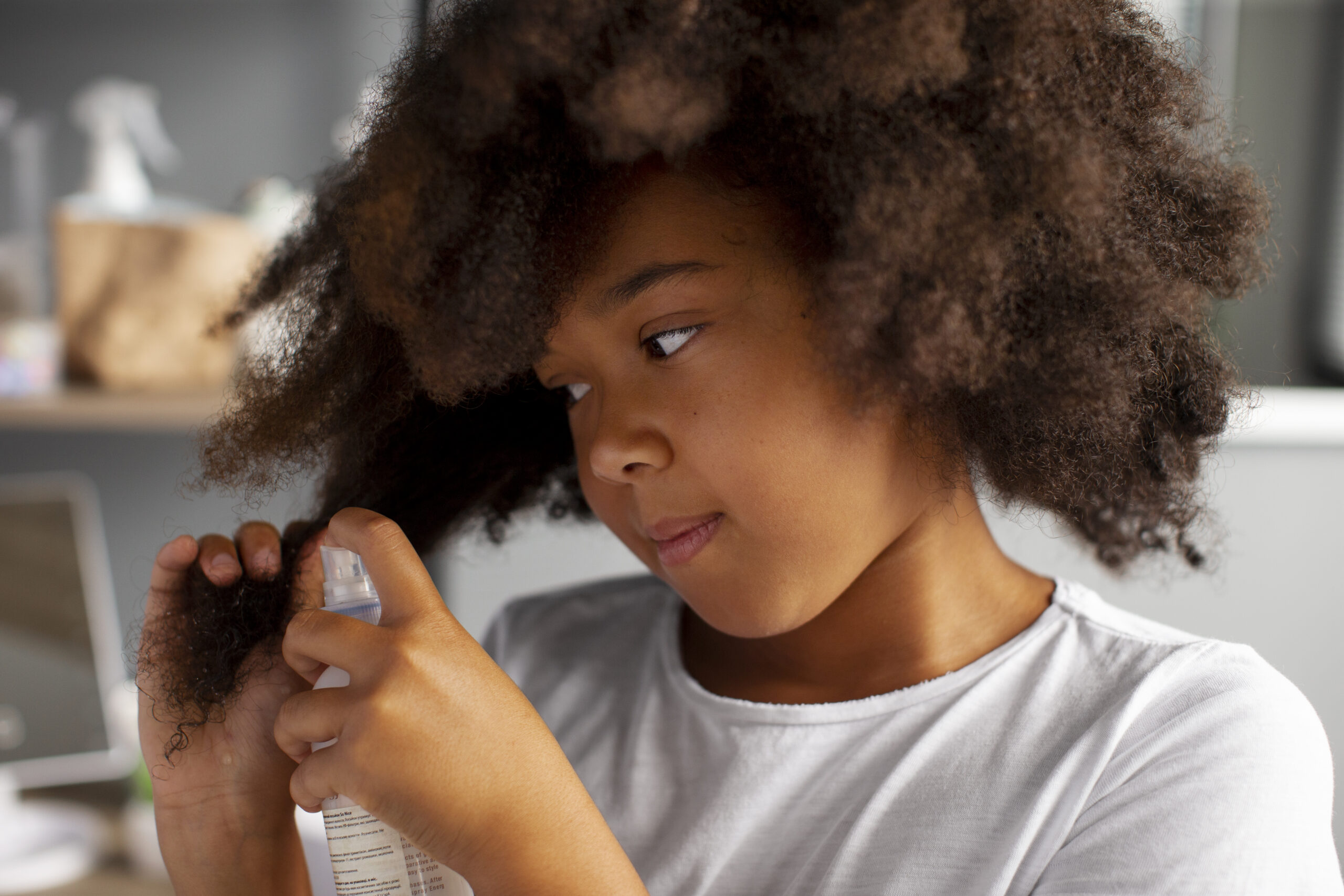 Applying leave-in conditioner to nourish and moisturize natural 4C hair