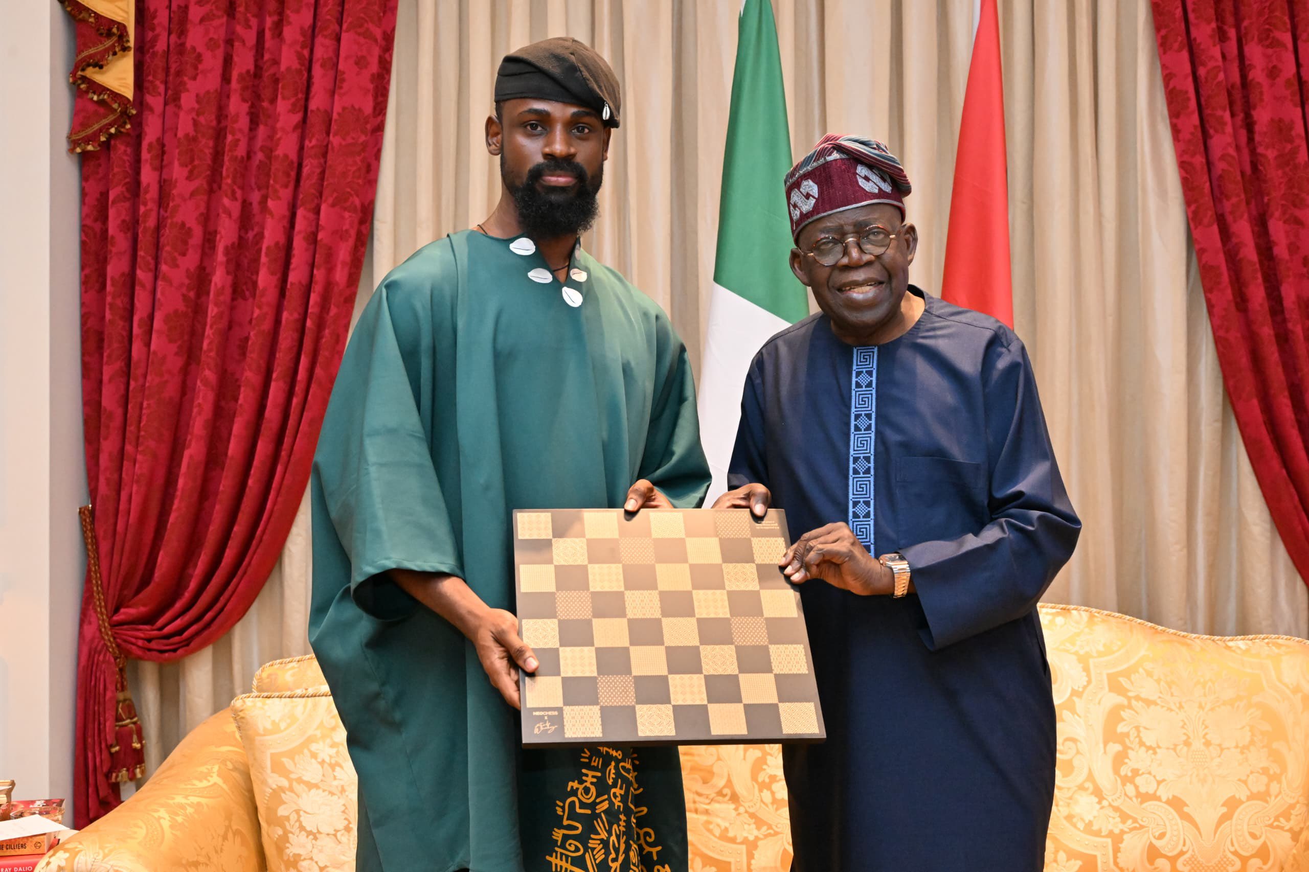 Tunde Onakoya presenting a gold-plated Adire chess board to President Bola Tinubu during a courtesy visit.